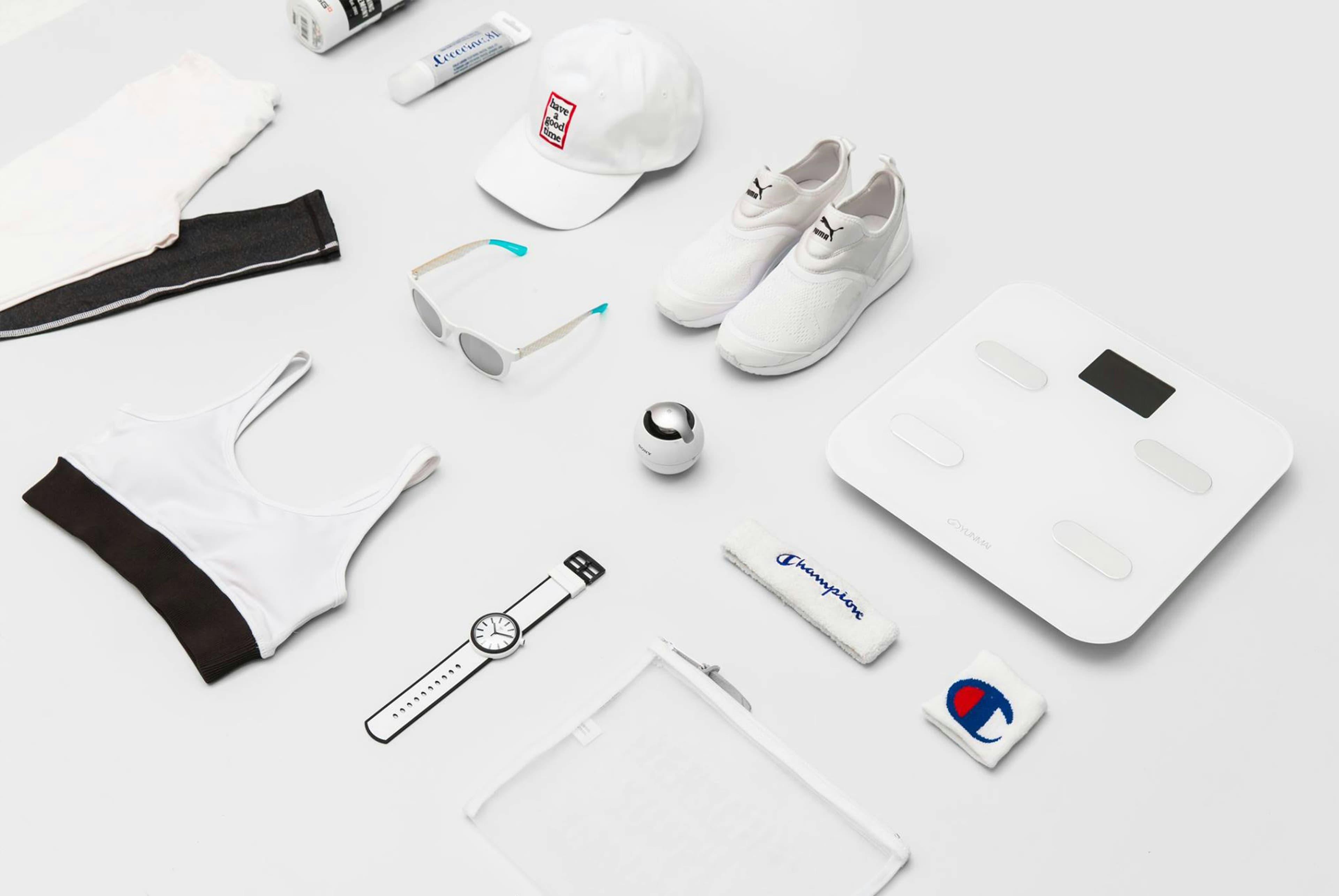 Neatly folded college sweatshirts and accessories on bright white surface, airy daylight