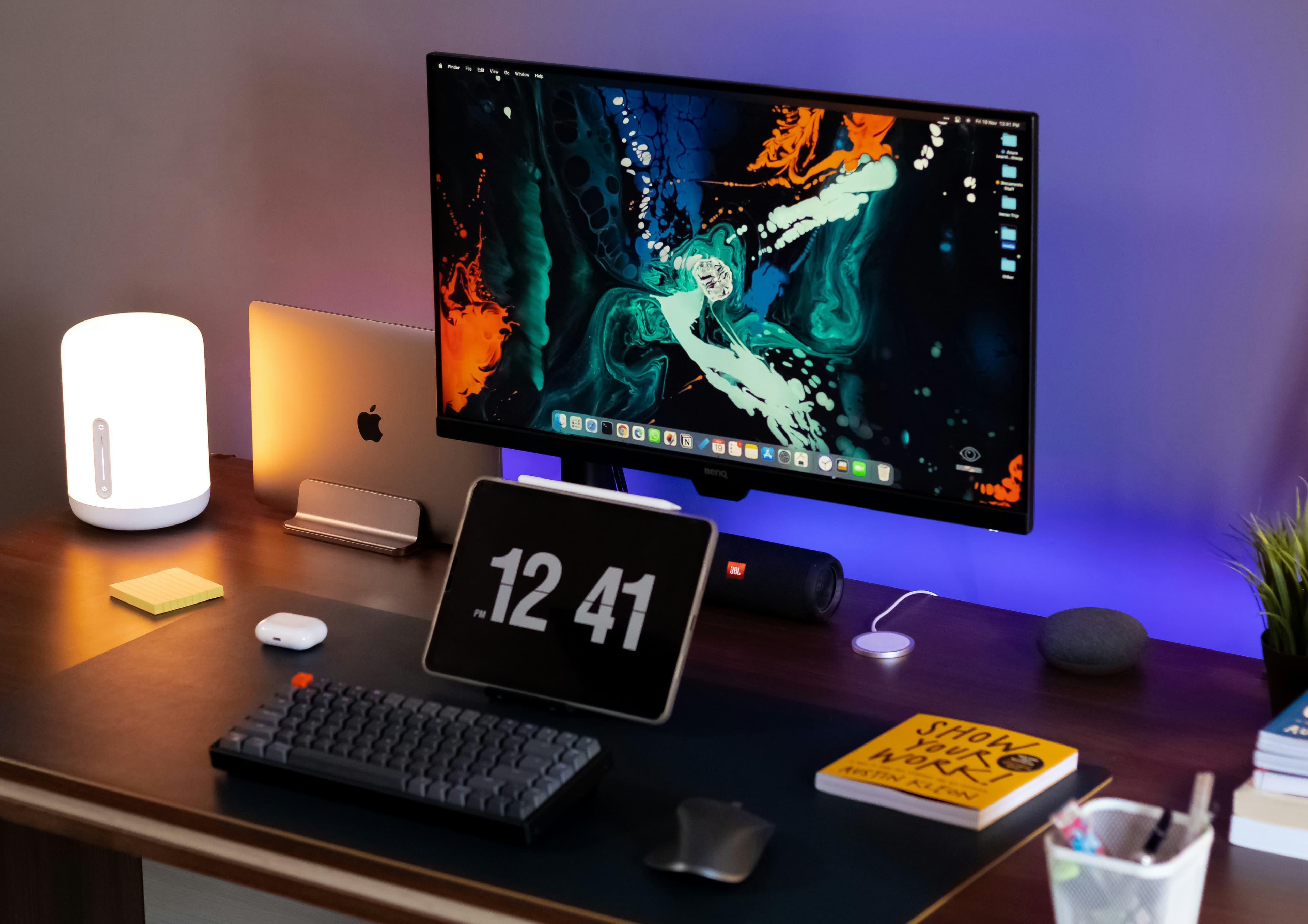 Laptop and gadgets on clean white desk, minimal tech setup, bright ambient light